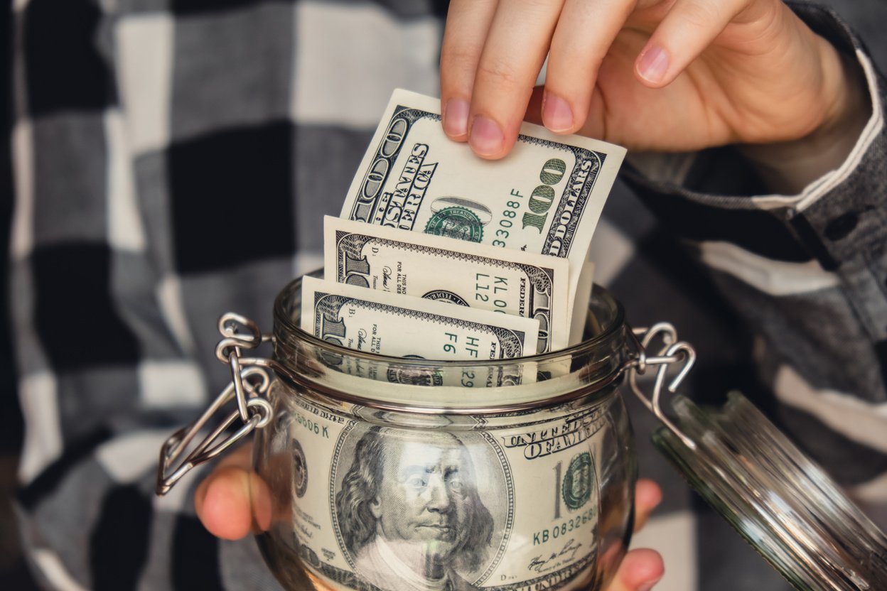 Dollar Banknote Saving Money in Glass Jar. Unrecognizable Woman Moderate Consumption and Economy Collecting Money. Tips. Business, Finance, Saving, Banking and People Concept. Extra Money, Passive Income